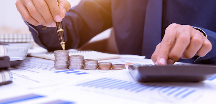 Persona con documentos y calculadora, haciendo presupuestos.