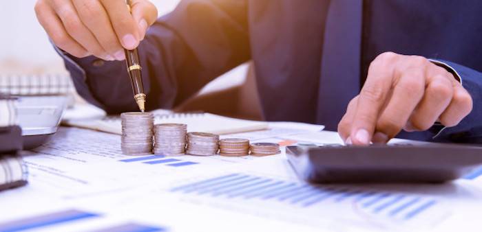 Persona con documentos y calculadora, haciendo presupuestos.